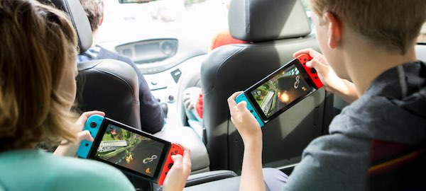 Two people playing Nintendo Switch portably