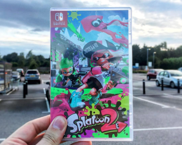 Holding a copy of Splatoon 2 for Nintendo Switch